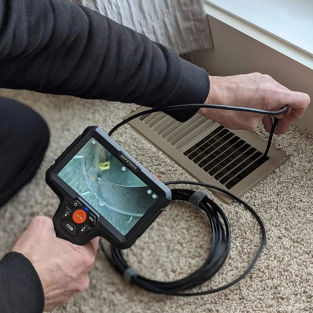 Pest Perfection technician checking a floor void with an inspection camera